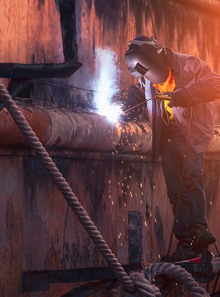 welder-on-scaffold-is-welding-the-old-rusty-vessel-2021-10-24-17-30-35-utc